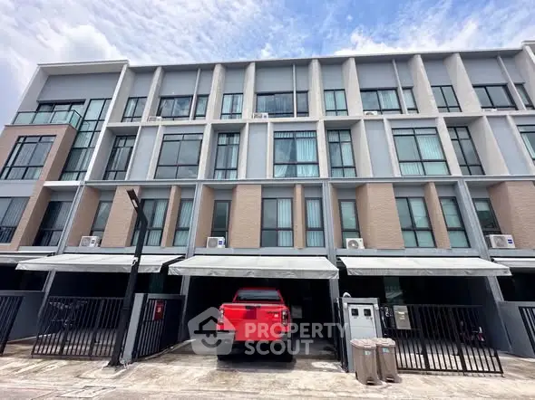 Modern townhouse with multiple floors and parking space, featuring sleek architectural design.