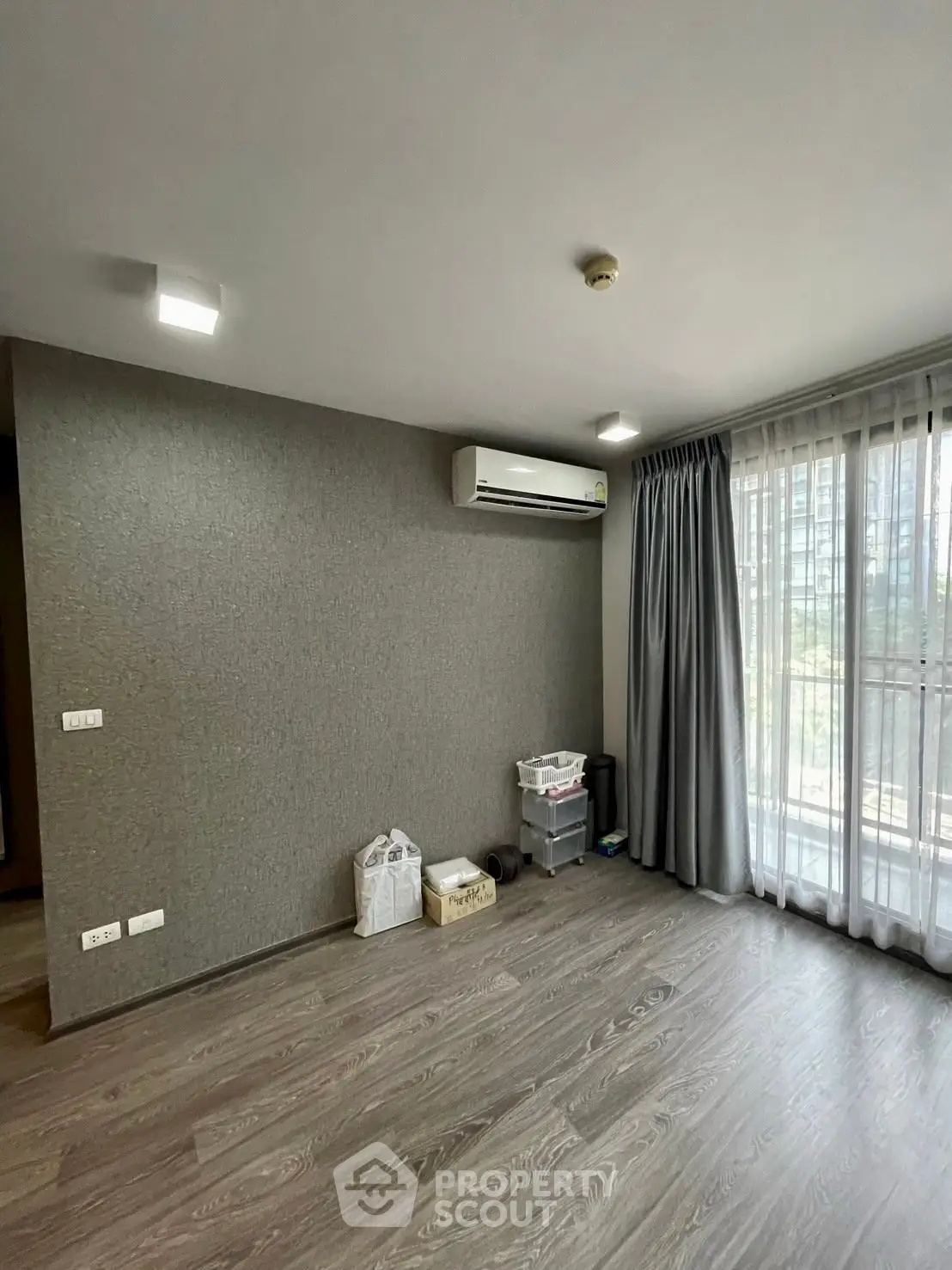 Spacious unfurnished living room with air conditioning and large window view.
