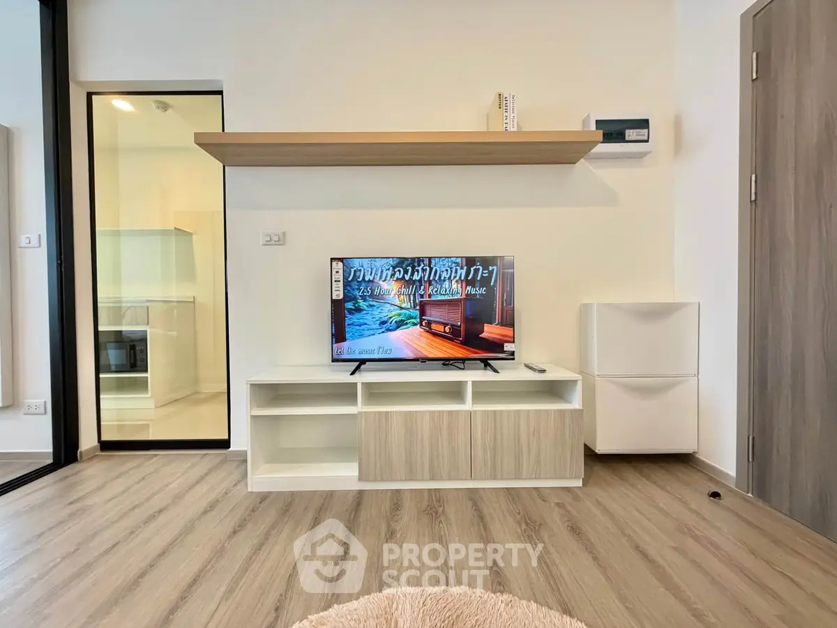 Modern living room with sleek TV unit and wooden flooring in a stylish apartment.