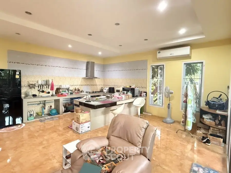 Spacious open-layout kitchen with modern appliances and cozy seating area, perfect for family gatherings.