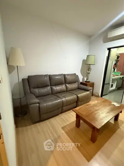 Cozy living room with leather sofa and wooden coffee table, perfect for relaxation.