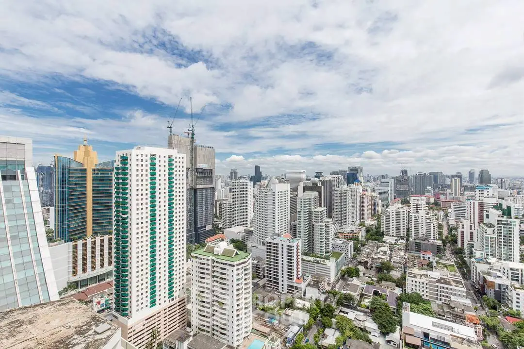 Stunning cityscape view of modern skyscrapers under a vibrant blue sky, perfect for urban living enthusiasts.