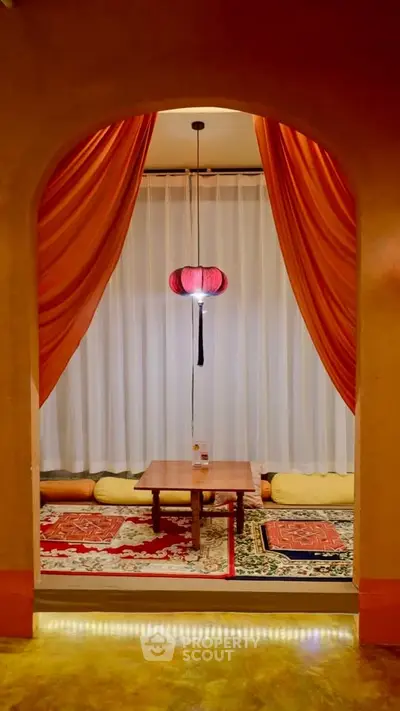 Cozy interior with oriental decor, featuring a low table and vibrant drapes, perfect for intimate gatherings.