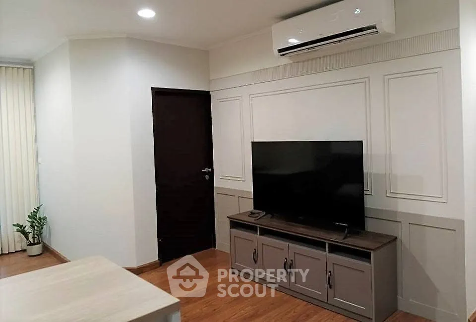 Modern living room with TV and air conditioning in stylish apartment.