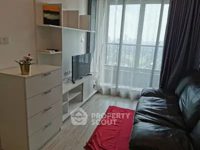 Modern living room with sleek furniture and city view from balcony.