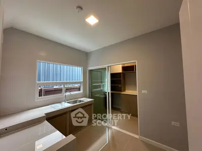 Modern kitchen with closed layout and sleek cabinetry in a bright, minimalist design.