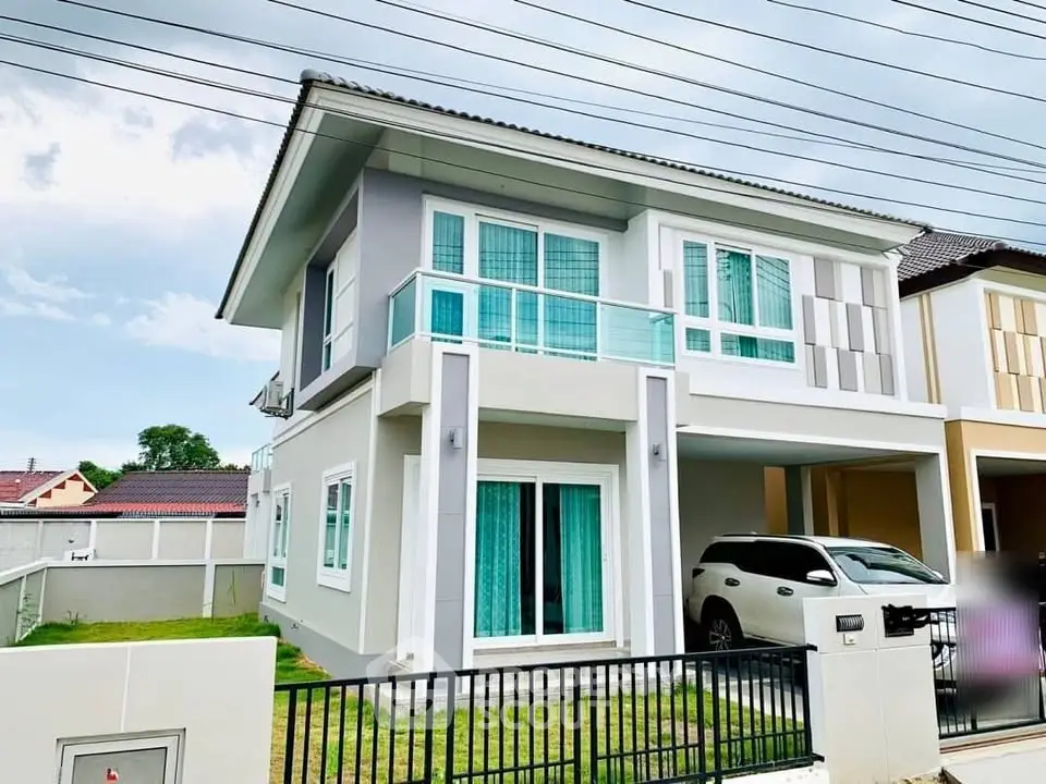 Modern two-story house with balcony and carport in a suburban neighborhood.