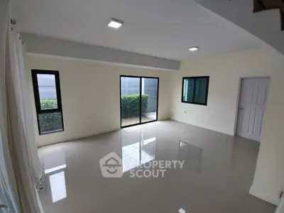 Spacious empty living room with large windows and glossy tile flooring
