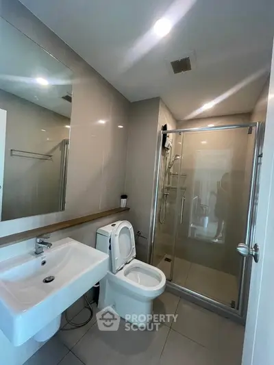 Modern bathroom with glass shower and sleek fixtures in a contemporary home.