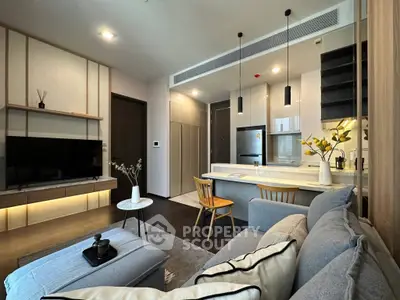 Modern living room with open kitchen, stylish decor, and cozy seating area in a contemporary apartment.