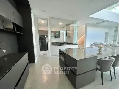 Modern open-layout kitchen with sleek black cabinetry and island in luxury home