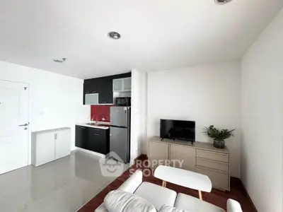 Modern living room with sleek kitchen, featuring stylish furniture and contemporary design.