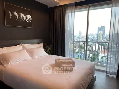 Luxurious bedroom with city view and modern decor in high-rise apartment.