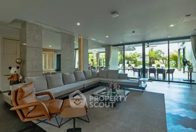 Luxurious open-plan living room with modern decor and expansive outdoor view.