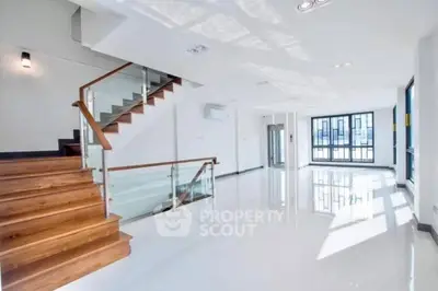 Spacious modern living room with wooden staircase and large windows