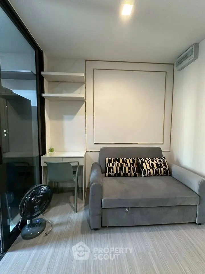 Modern living room with stylish sofa and workspace in compact apartment