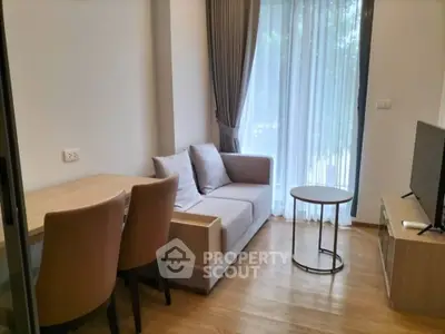 Modern living room with cozy sofa, dining table, and large window for natural light.