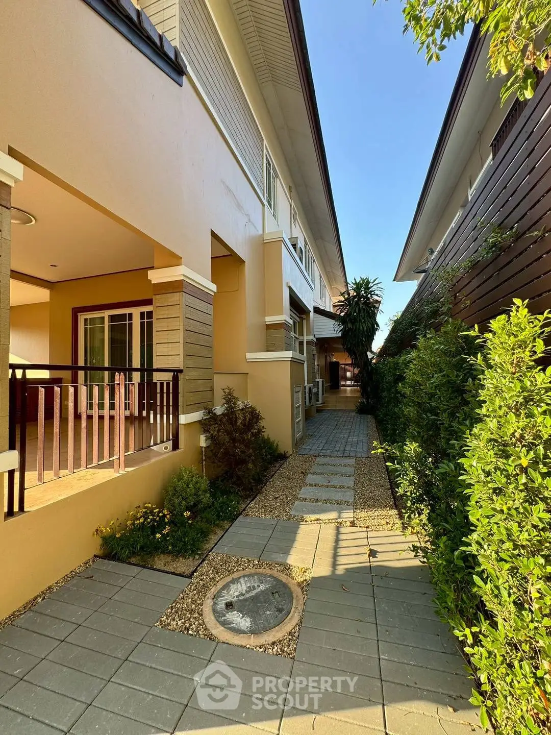 Charming townhouse exterior with lush garden path and modern design.