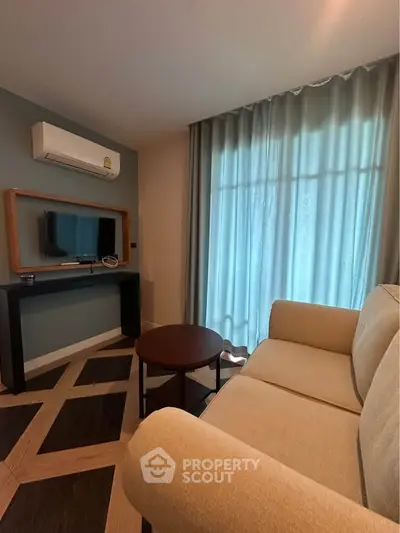 Cozy living room with modern decor, featuring a comfortable sofa, TV, and large window with curtains.