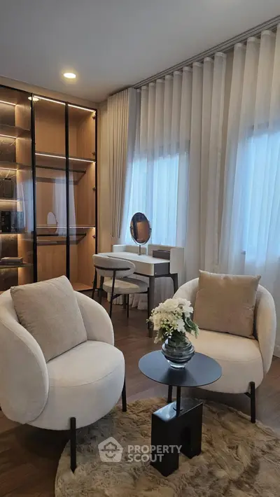 Elegant living room with plush chairs, stylish decor, and natural light