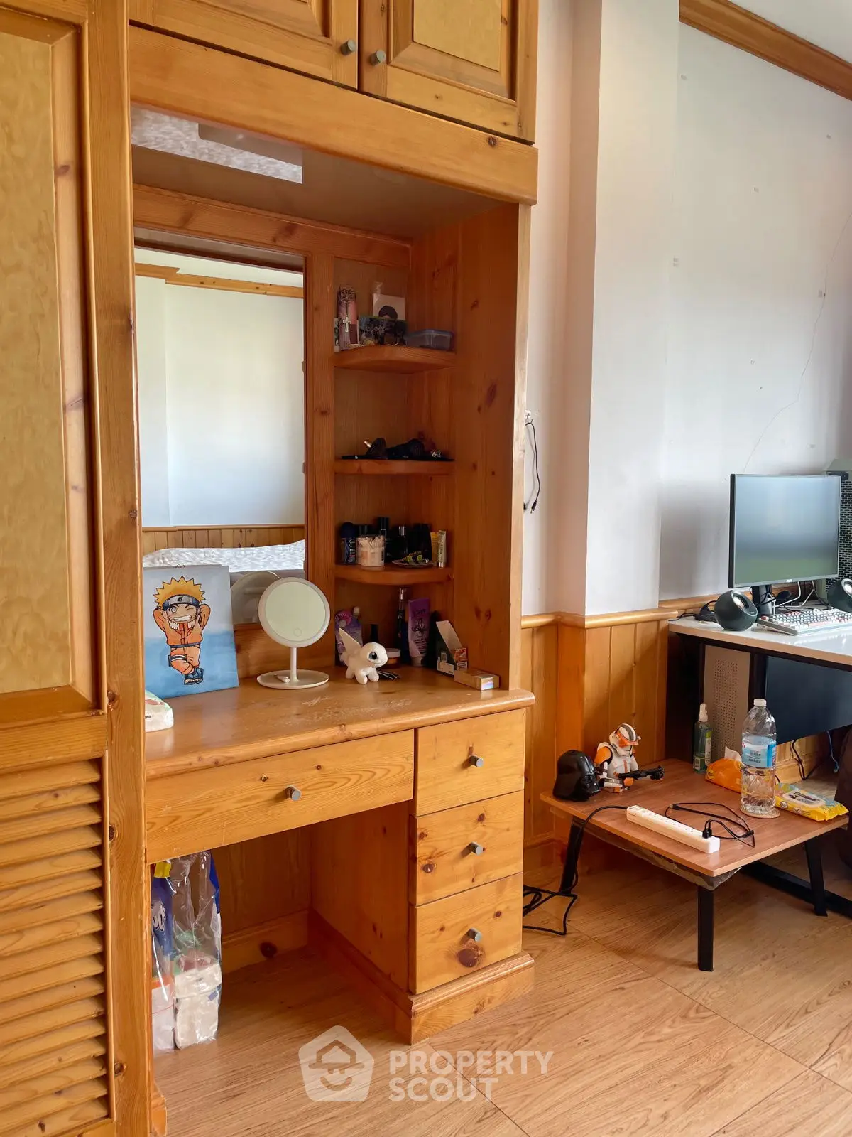 Cozy study area with wooden desk and shelves, ideal for home office setup.