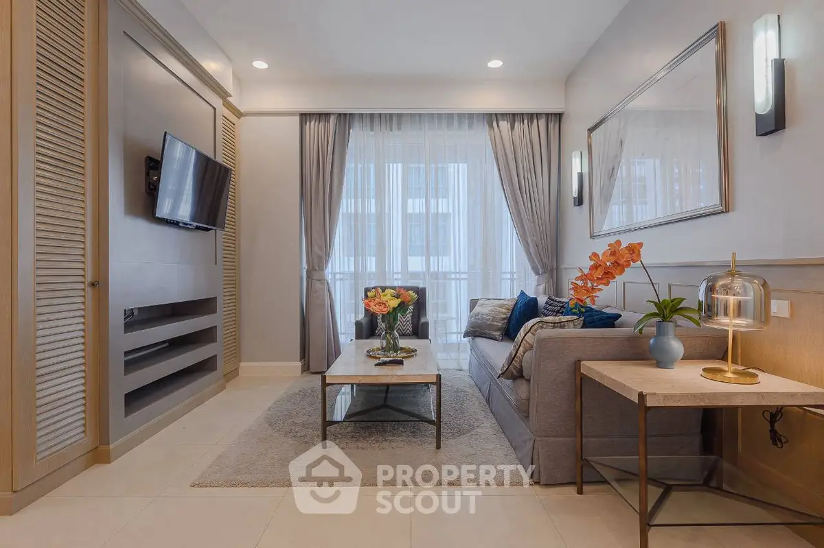 Elegant living room with modern decor, cozy seating, and natural light through large windows.