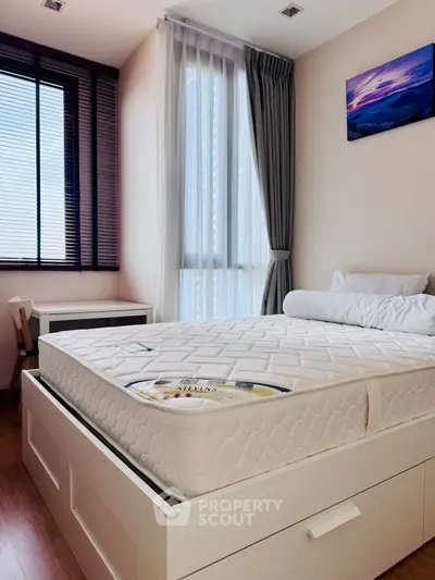 Modern bedroom with large window and stylish decor in a high-rise apartment.