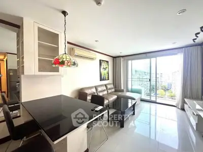 Spacious modern living room with large windows and stylish decor in a high-rise apartment.