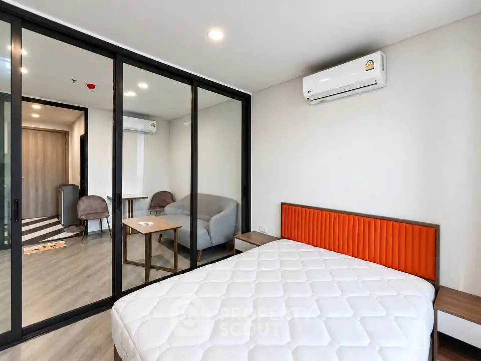 Modern bedroom with glass partition and air conditioning in stylish apartment