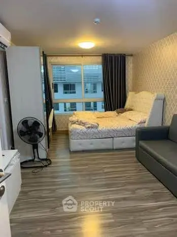 Cozy bedroom with modern decor and large window in a stylish apartment.