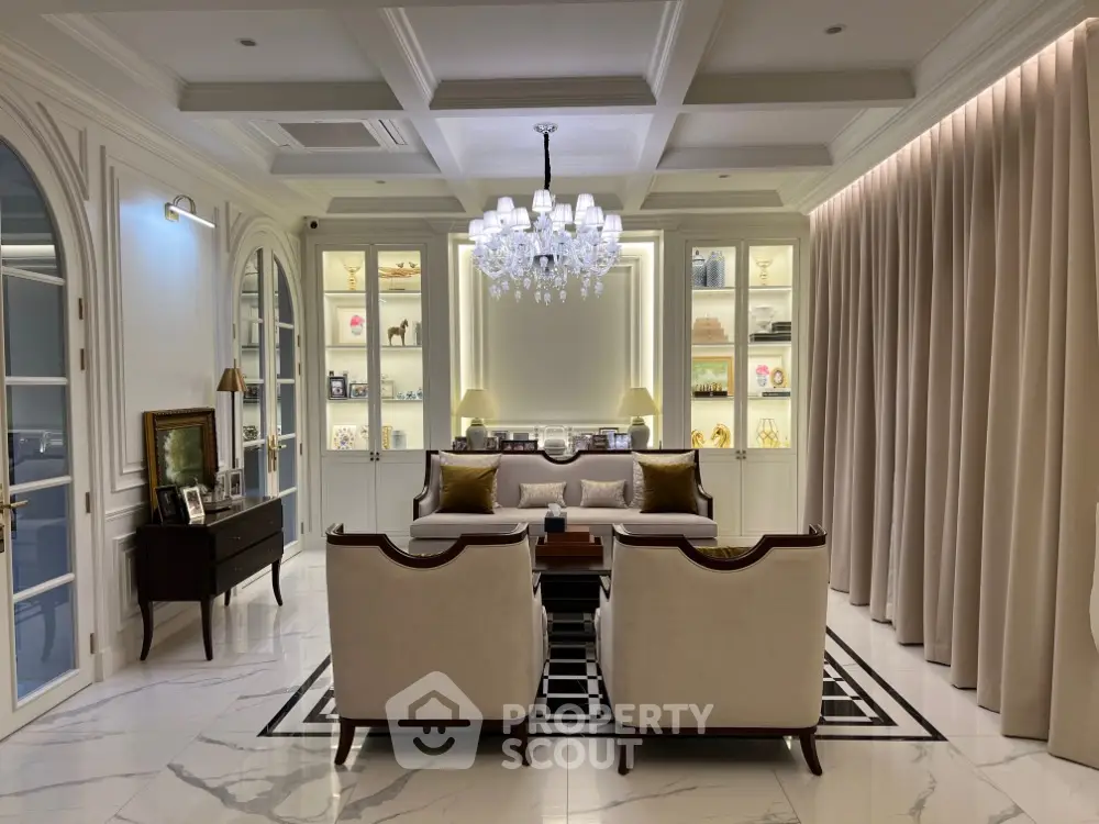 Luxurious living room with elegant chandelier and plush seating in a sophisticated setting.