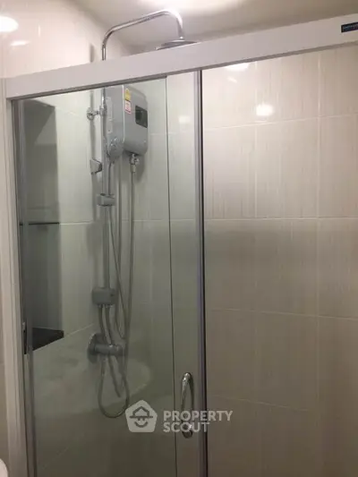 Modern bathroom with glass shower enclosure and sleek fixtures.