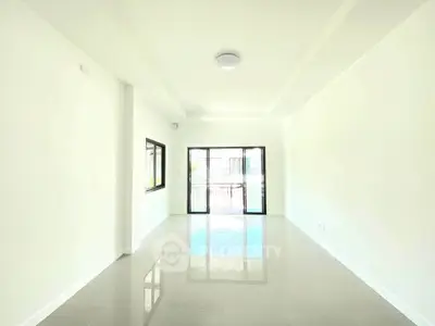 Spacious and bright living room with large windows and glossy floors