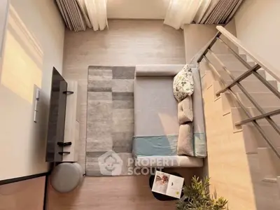 Modern living room with stylish sofa, TV, and elegant staircase in cozy apartment.