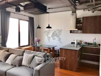 Modern open-layout living room with stylish kitchen and cozy seating area.