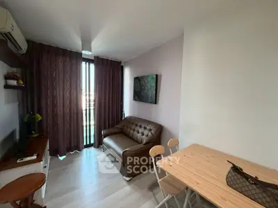 Cozy living room with modern decor and natural light, featuring a leather sofa and dining area.