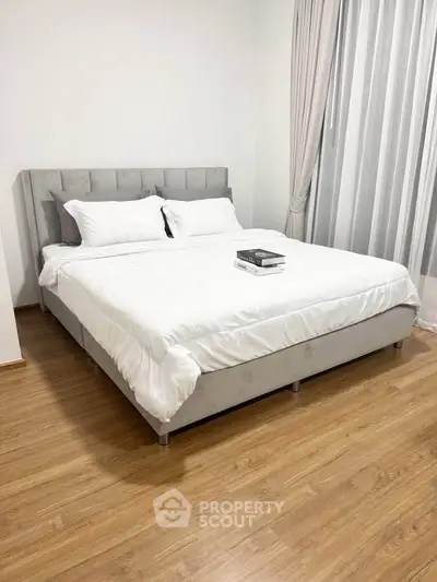 Spacious bedroom with elegant bed and wooden flooring, perfect for relaxation.