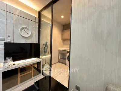 Modern kitchen with sleek design and integrated appliances, featuring a washing machine and stylish decor.