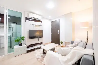 Modern living room with cozy sofa and wall-mounted TV in bright apartment.