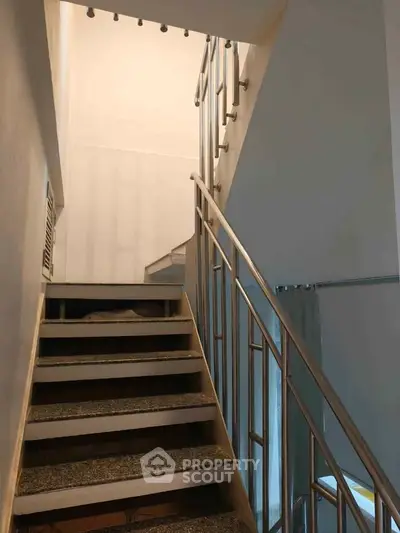 Modern staircase with sleek metal railing in a contemporary home interior.