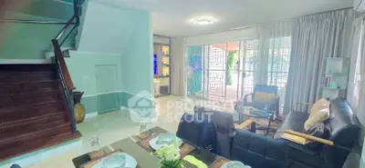 Spacious living room with modern decor and large windows opening to a patio, perfect for family gatherings.
