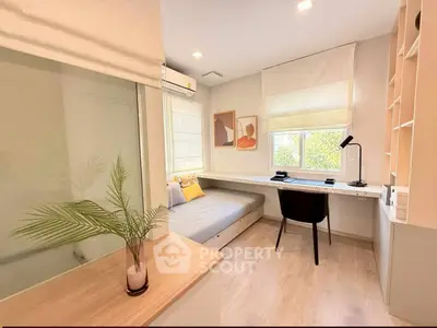 Modern study room with sleek desk, cozy daybed, and stylish decor in bright natural light.