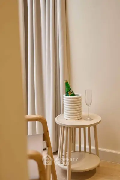 Elegant interior with minimalist side table and champagne glass