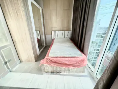 Modern bedroom with large window and city view, featuring a single bed and mirrored wardrobe.