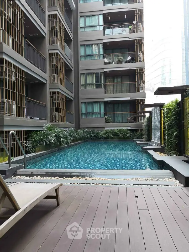 Modern apartment building with stylish pool and lush greenery, perfect for urban living.