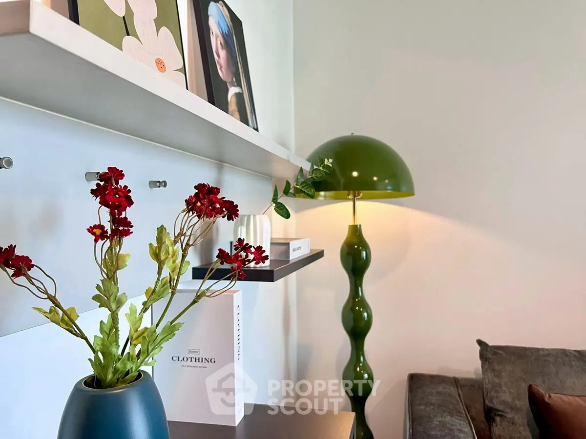 Stylish living room corner with modern green lamp and decorative shelves.