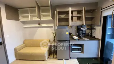 Modern compact kitchen with open cabinets and cozy seating area in stylish apartment.