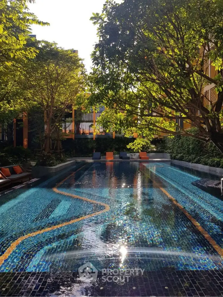Luxurious outdoor pool surrounded by lush greenery in a serene residential complex.