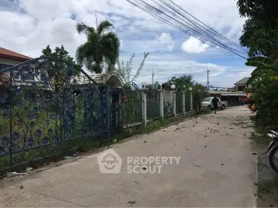 Charming residential street with ornate gate and lush greenery