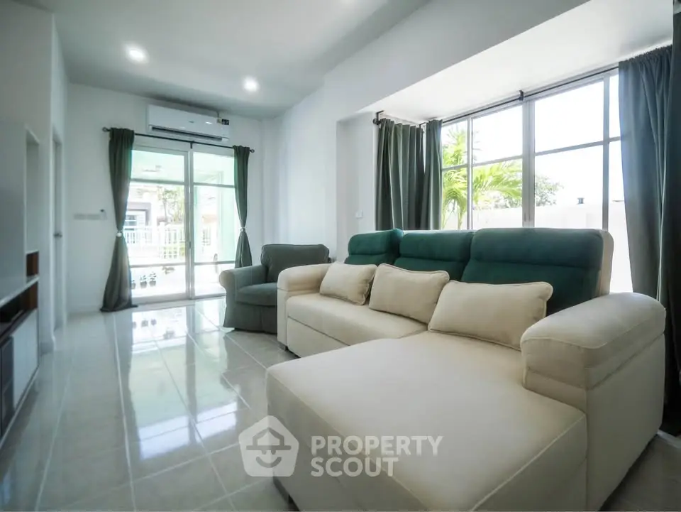 Spacious living room with modern furniture and large windows offering natural light.